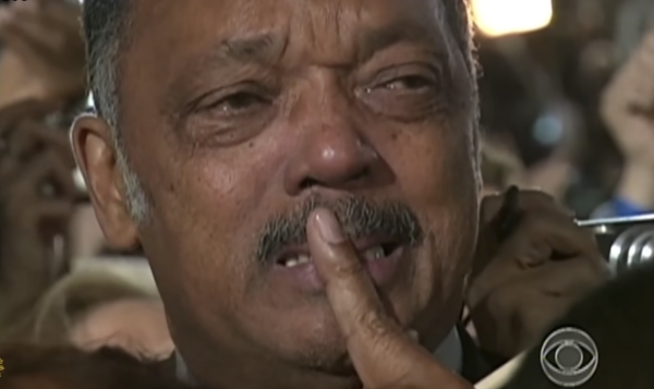 Jesse Jackson with finger to lips in thoughtful moment