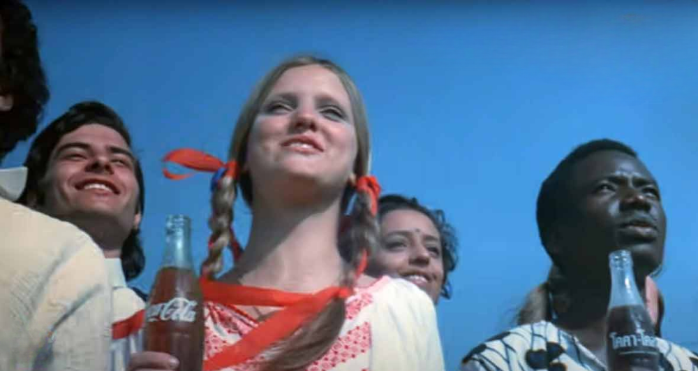 Diverse group holding Coca-Cola bottles, 1970s Hilltop TV commercial still