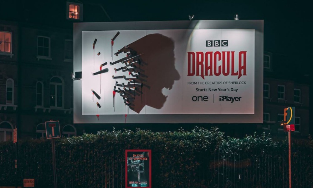 BBC Dracula billboard at night with stakes forming vampire silhouette