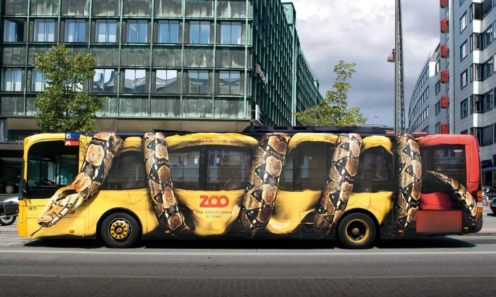 Copenhagen Zoo bus wrap ad with giant python squeezing yellow city bus