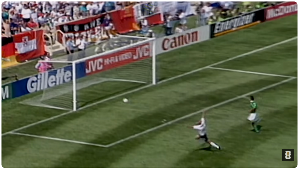 Soccer player scoring a goal in packed stadium during match