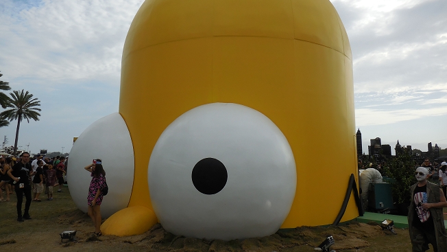 Giant inflatable yellow character structure at outdoor festival