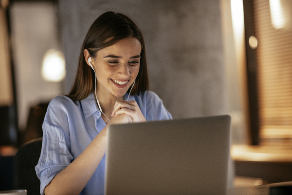 Customer Experience - Smiling woman looking at a laptop screen.
