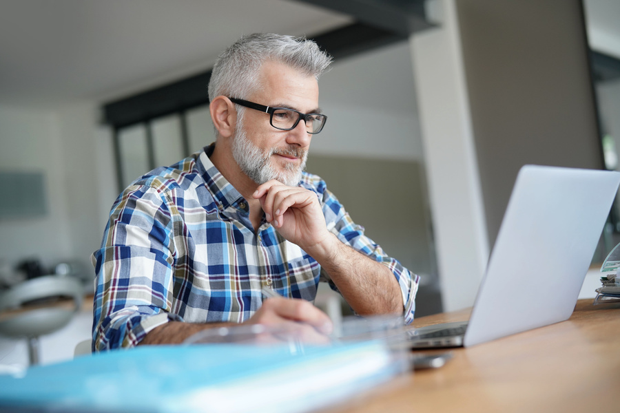 Man reading information on a laptop.
