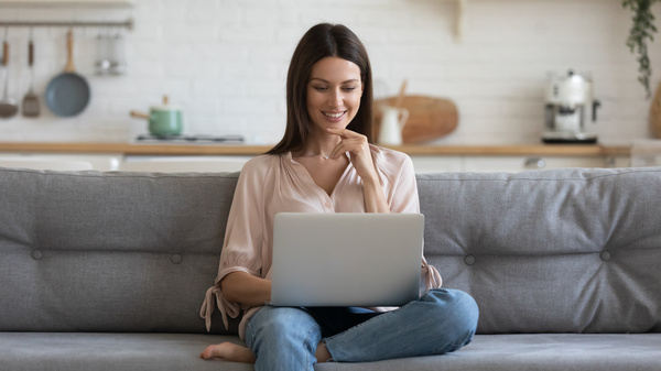 customer experience - sitting on a couch with a laptop.