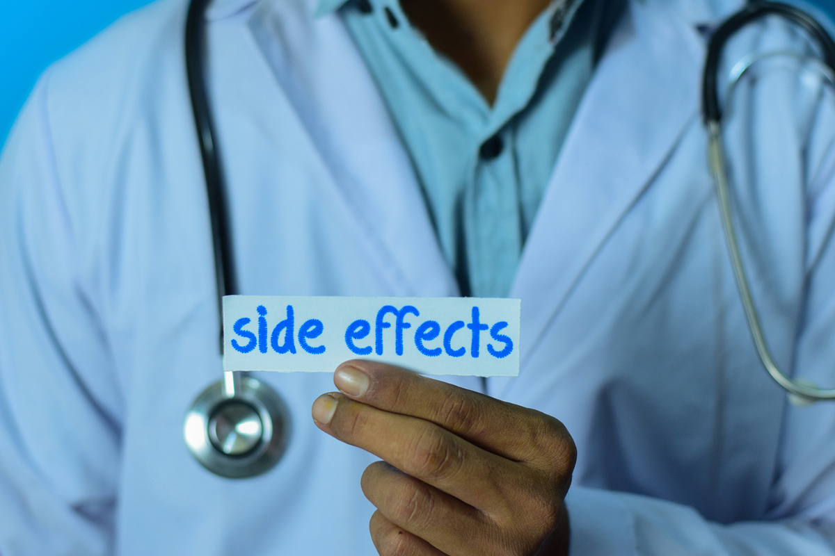 Medical doctor holding a piece of paper labeled side effects.