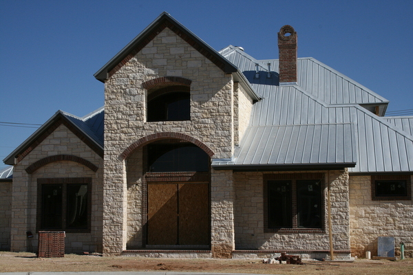 Stone front home with metal roof.