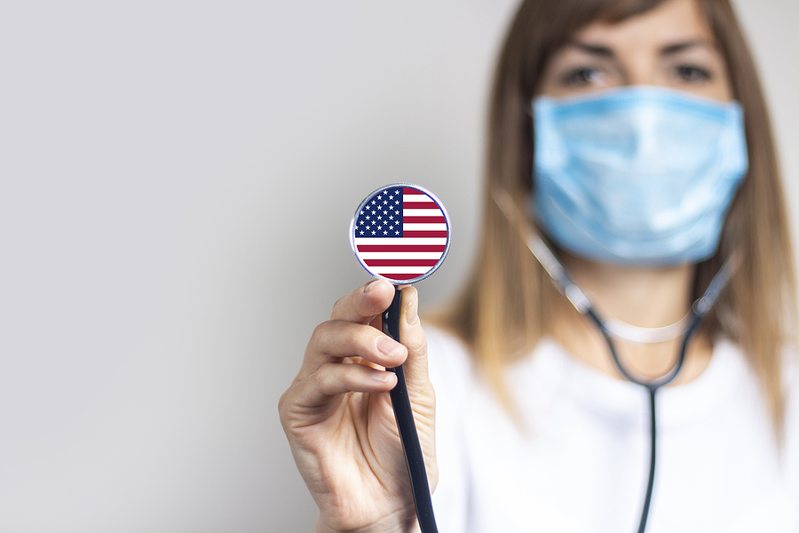 Medical personnel holding a stethoscope with an American flag.
