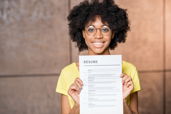 Smiling person holding a resume.