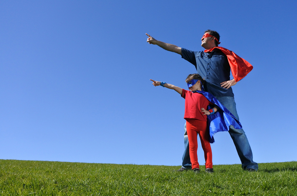 Parent and child dressed as superheros.