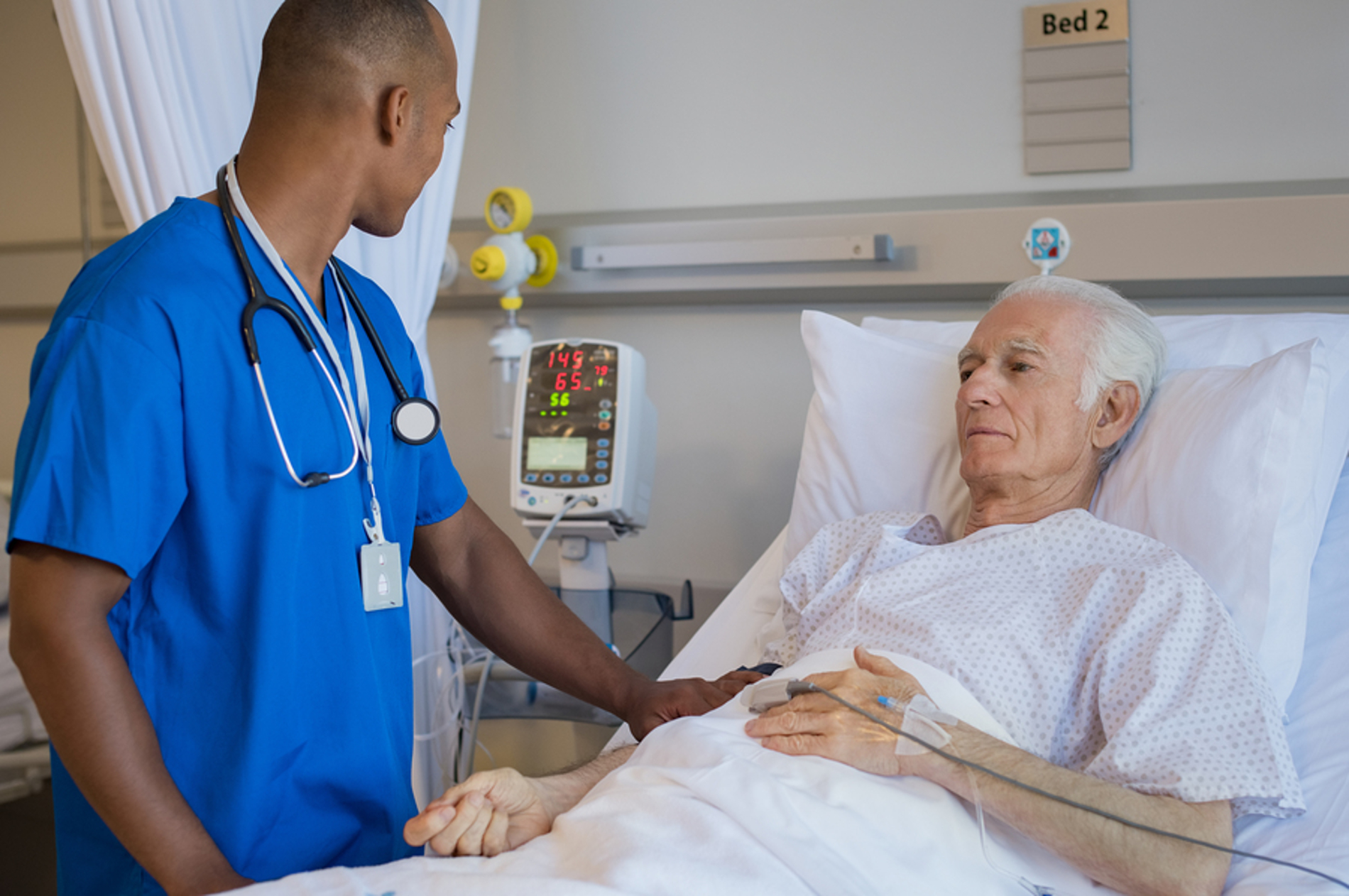 Older male patient getting assistance from a nurse.