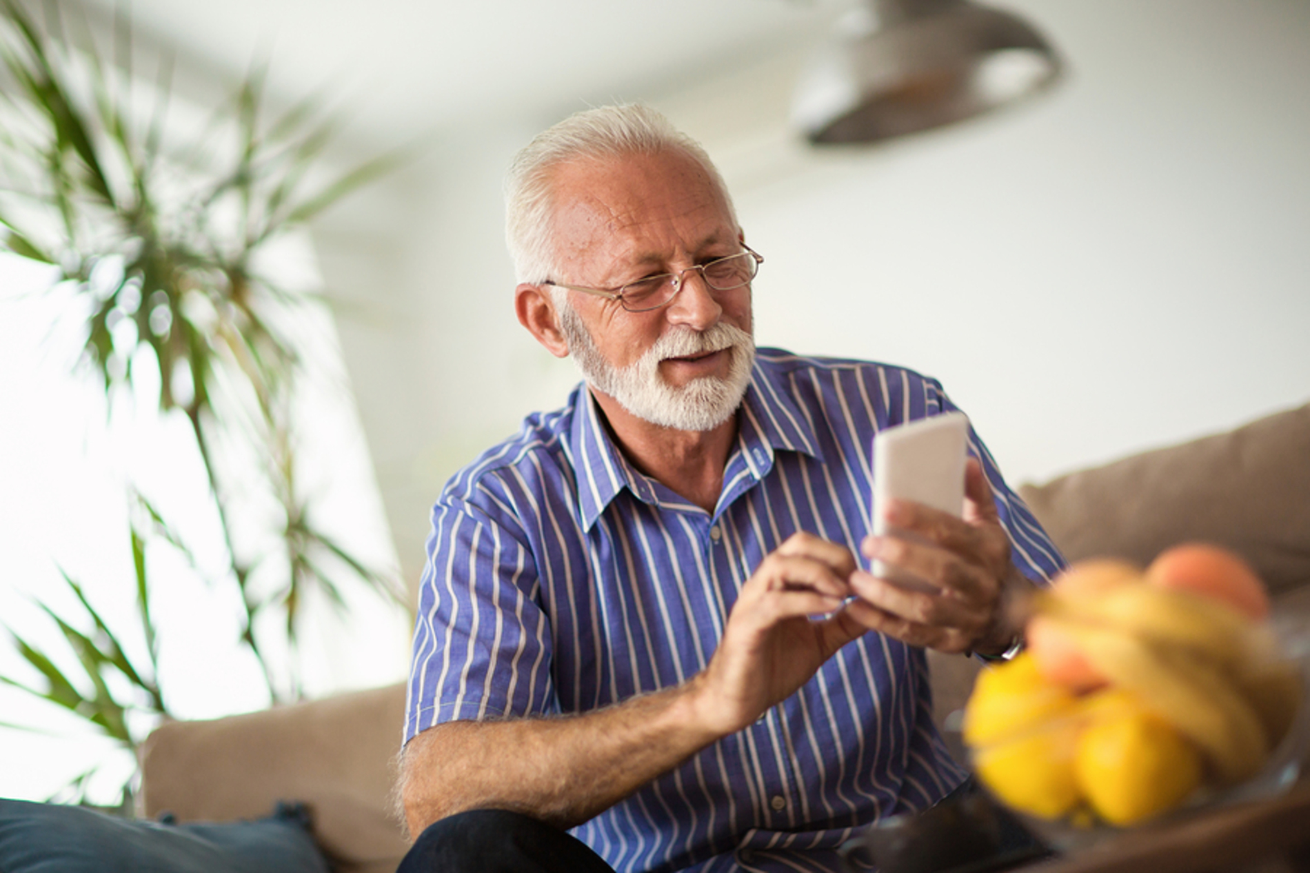 Older man typing on a phone.