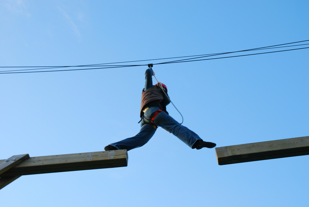 Construction worker walking along a beam.