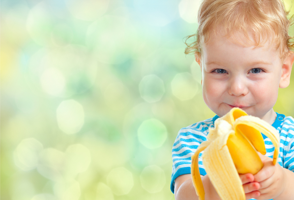 Young child eating a banana.