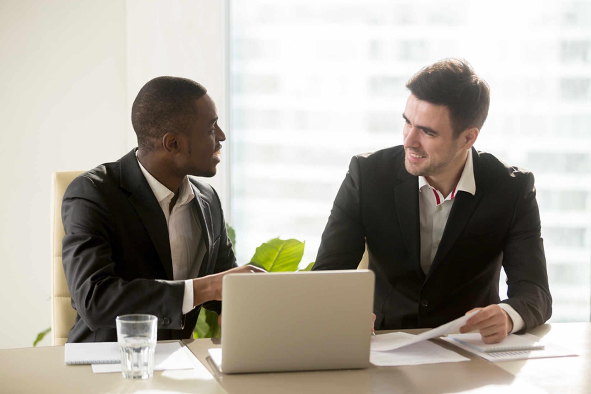 Two men in business suits discussing a project.