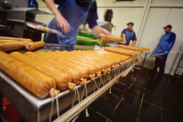 Workers packaging up sausages.