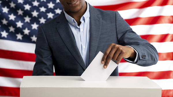 Placing a ballot in a voter box.