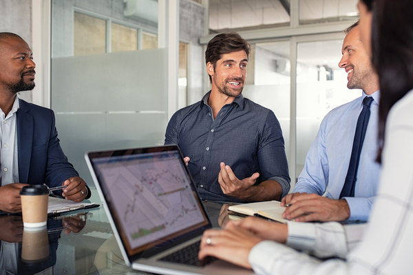 Group of colleagues having a discussion around a conference table.