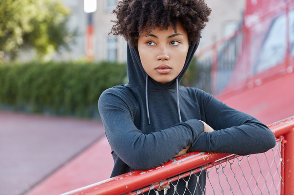 Teen leaning on a fence.