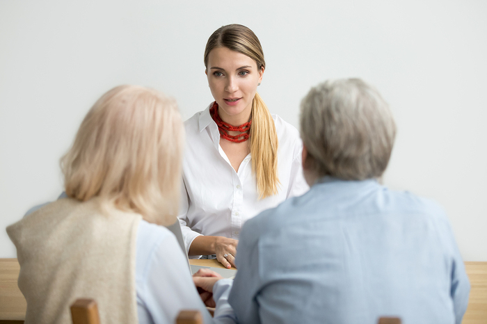 Woman speaking with an elderly couple.