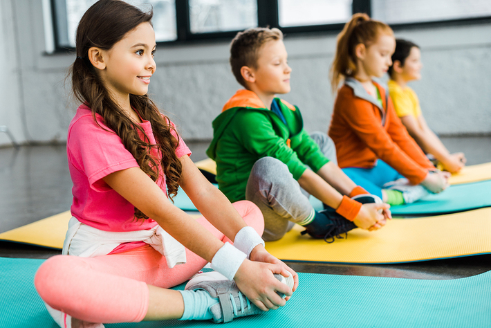 Group of children participating in a yoga class.