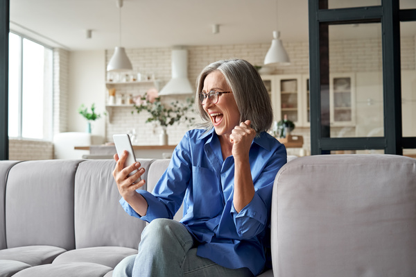 Smiling woman looking at her phone. personalized videos for customers