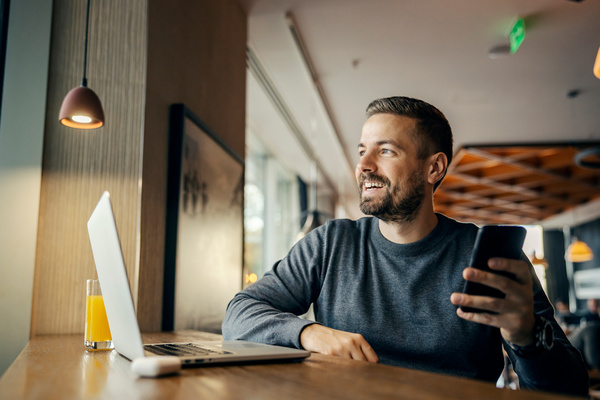 Man sitting at a table with his laptop. - personalized videos for customers