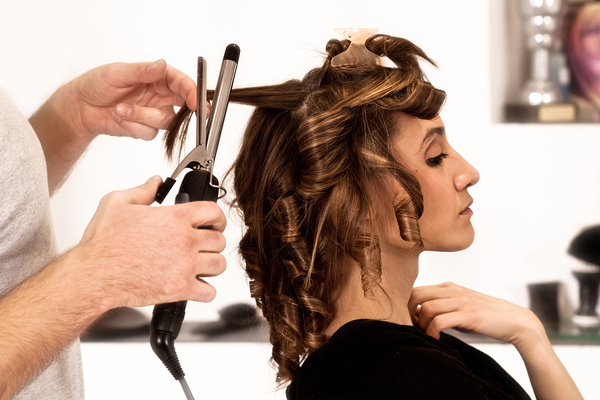 Woman getting her hair curled at a beauty salon.