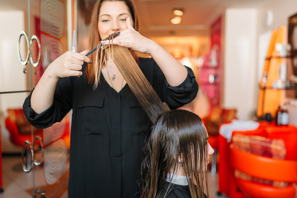 Woman at a hair salon getting her hair cut.