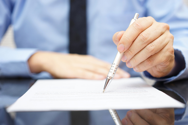 Person writing on a document.