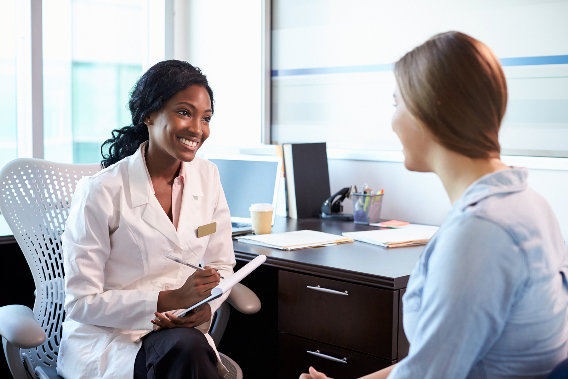 Medical doctor discussing information with a female patient. Medical doctor discussing information with a female patient.