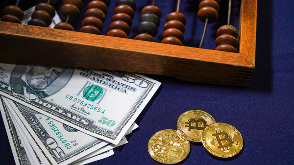 Paper money, gold coins with bitcoin symbols and an abacus. 