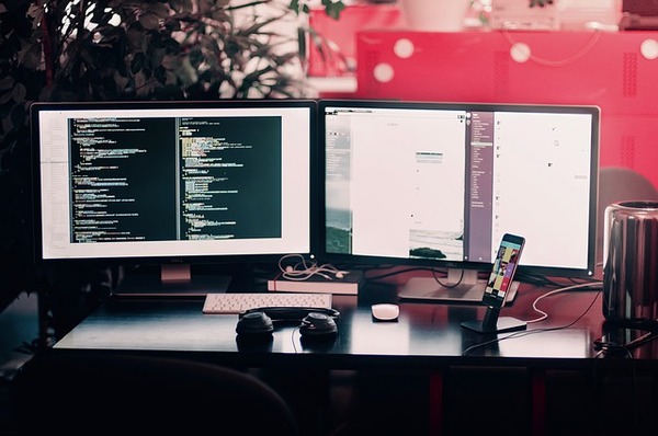 Two computer monitors on a desk.