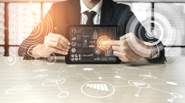 Data analytics image Man pointing to a circle chart on a tablet.