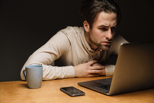 Data Quality Metrics image 1 - Man looking intently at his laptop screen.