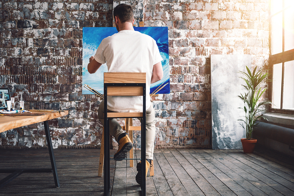 Man painting on a canvas.