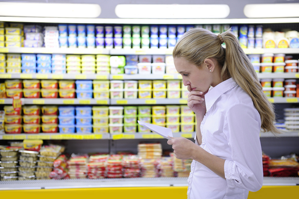 Woman reading her shopping list at a grocery.