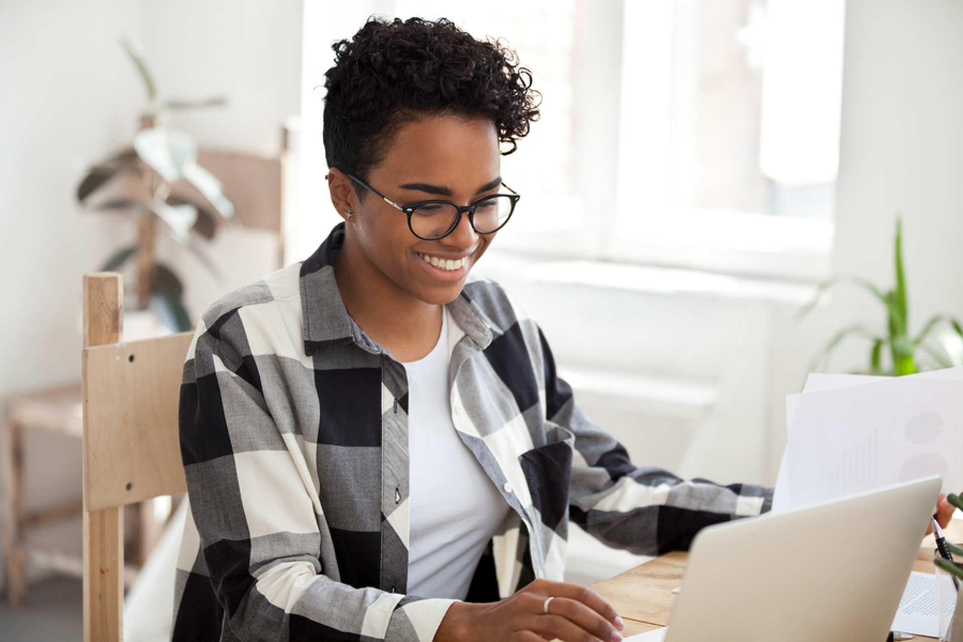 Woman smiling while looking at her laptop computer. Woman smiling while looking at her laptop computer.