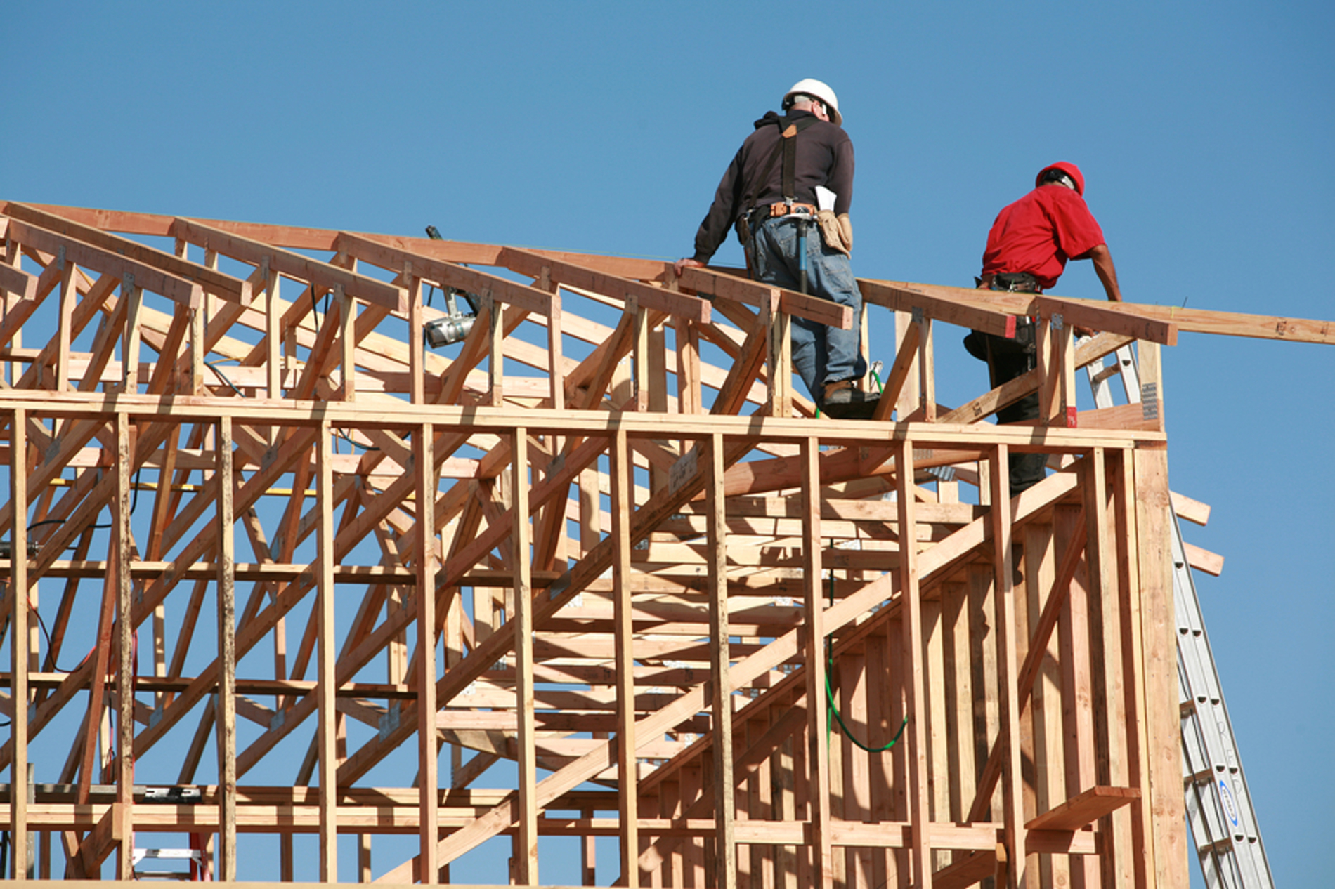 Construction site with two workers on a roof. Construction site with two workers on a roof.