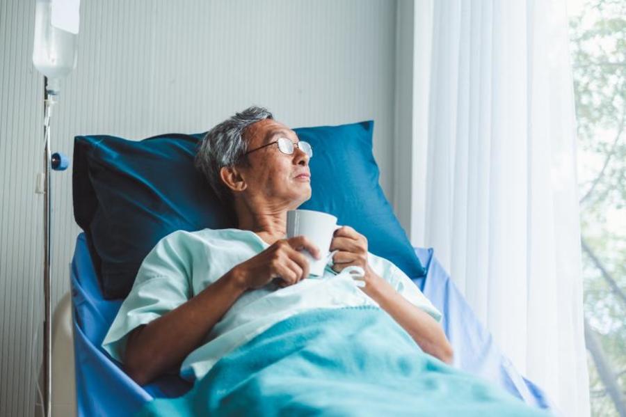 Patient in a hospital bed next to a window.