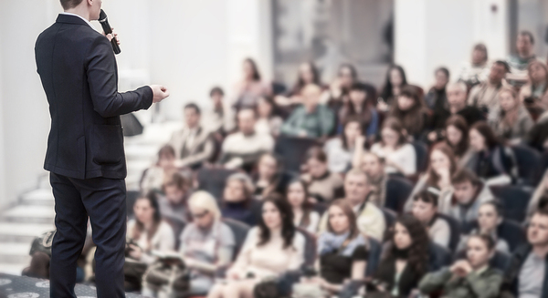 Speaker on stage in front of a large audience.