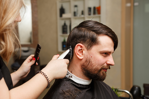 Man getting his hair cut in a salon.