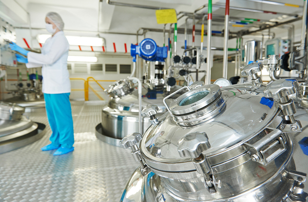 Person working in a chemical warehouse wearing protective clothing.