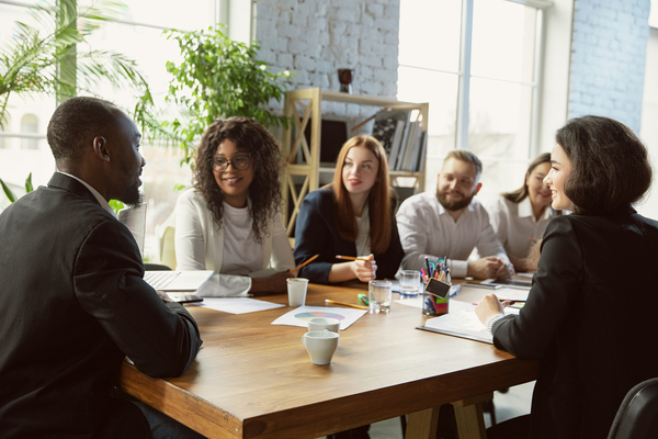 Group of people sitting around a conference table discussing ideas.