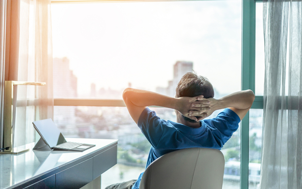 Person sitting in a chair looking at a window appearing relaxed.