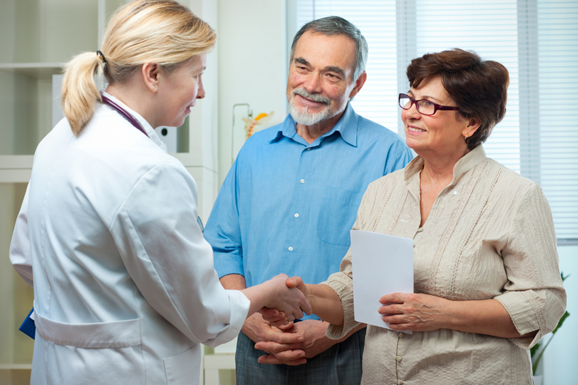 Medical doctor shaking hands with a female patient.