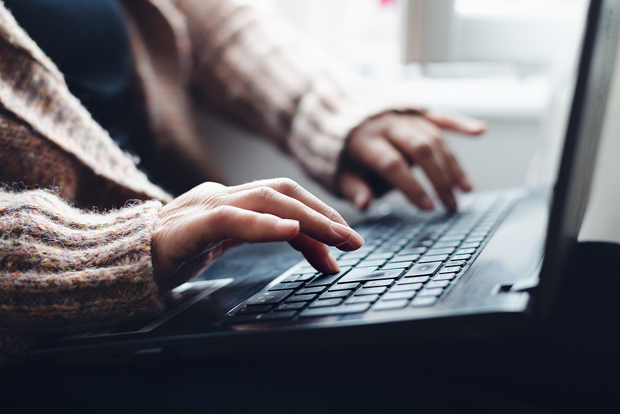 Person typing on a laptop computer keyboard.