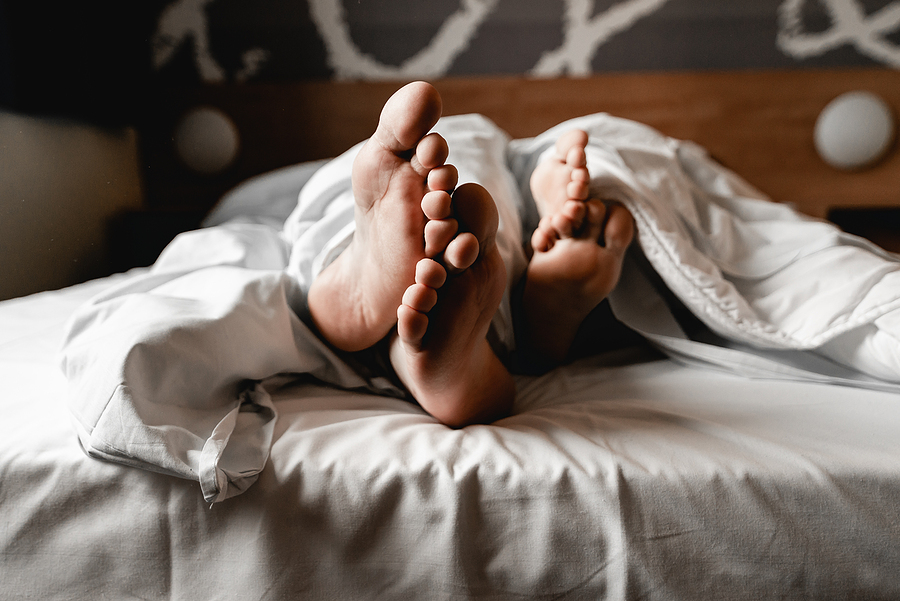 Feet sticking out from under blankets.