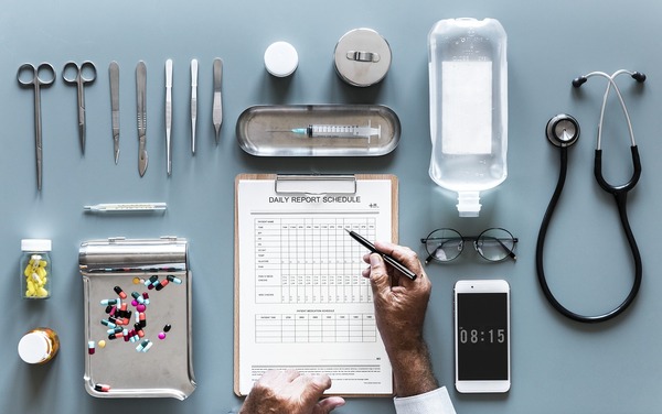 Medical equipment on a tabletop including stethoscope, jars of medication and needles.