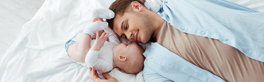 Parent and baby lying down together.